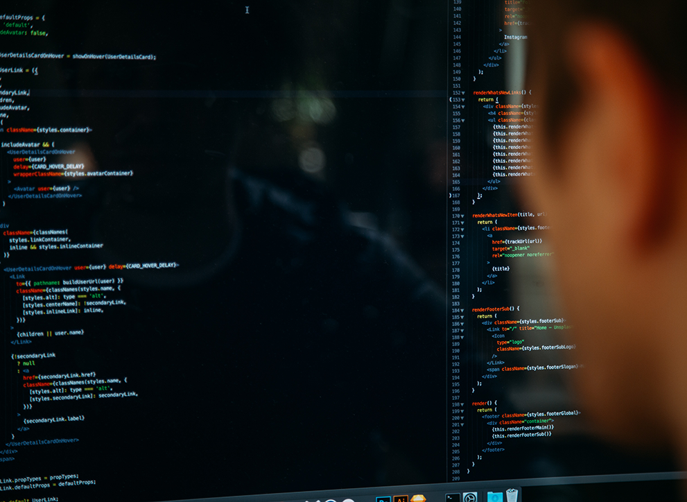 Person sitting in front of a screen of code.